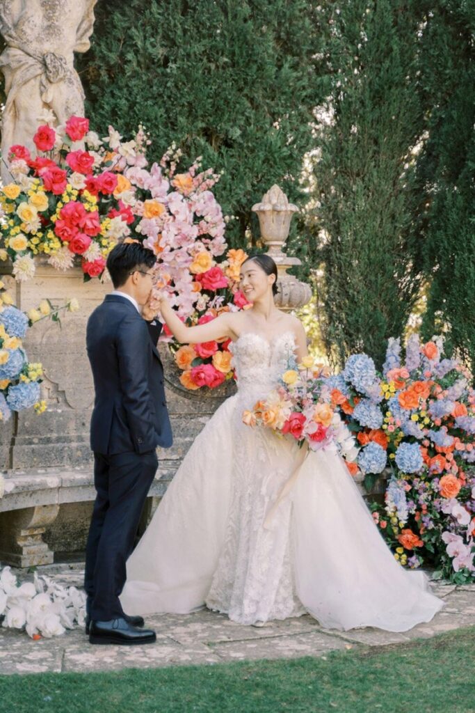 A couple in front of the ceremony florals for their La Foce wedding