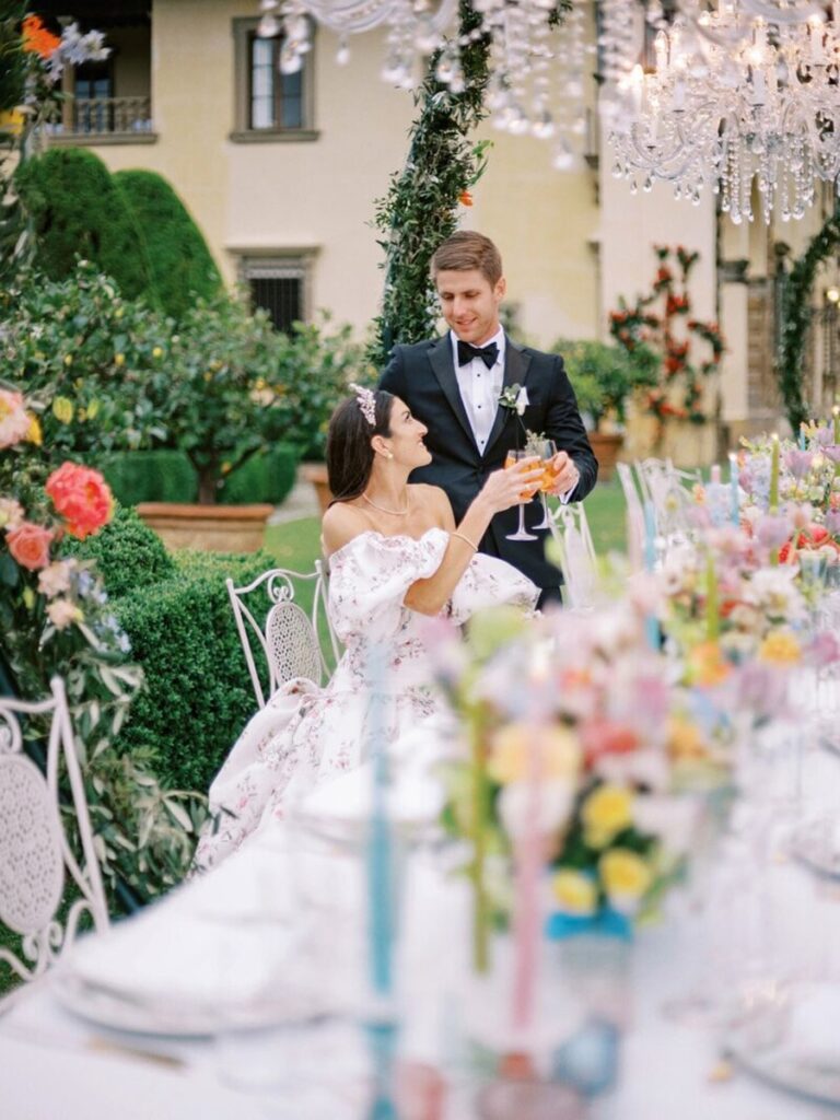 Wedding couple sitting at the wedding table at Villa Gamberaia in Florence